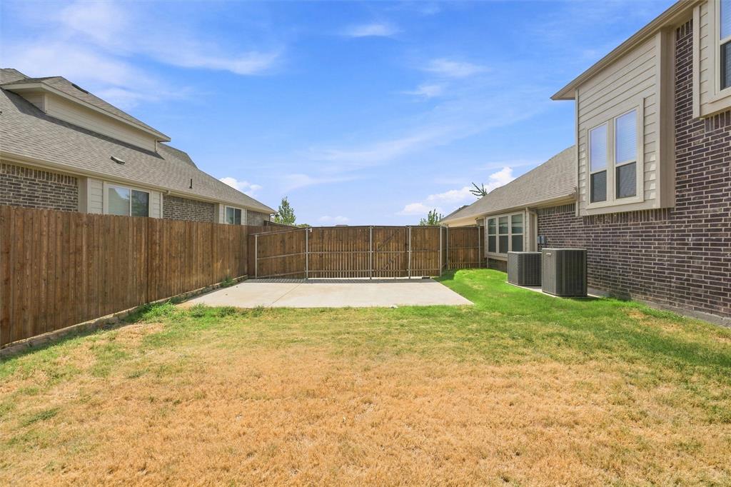 5225 Rowlan Row Midlothian, TX 76065 - Photo 32 of 33 Spacious backyard featuring a freshly poured concrete patio, mature landscaping with established lawn areas, and sturdy wood-finish privacy fencing