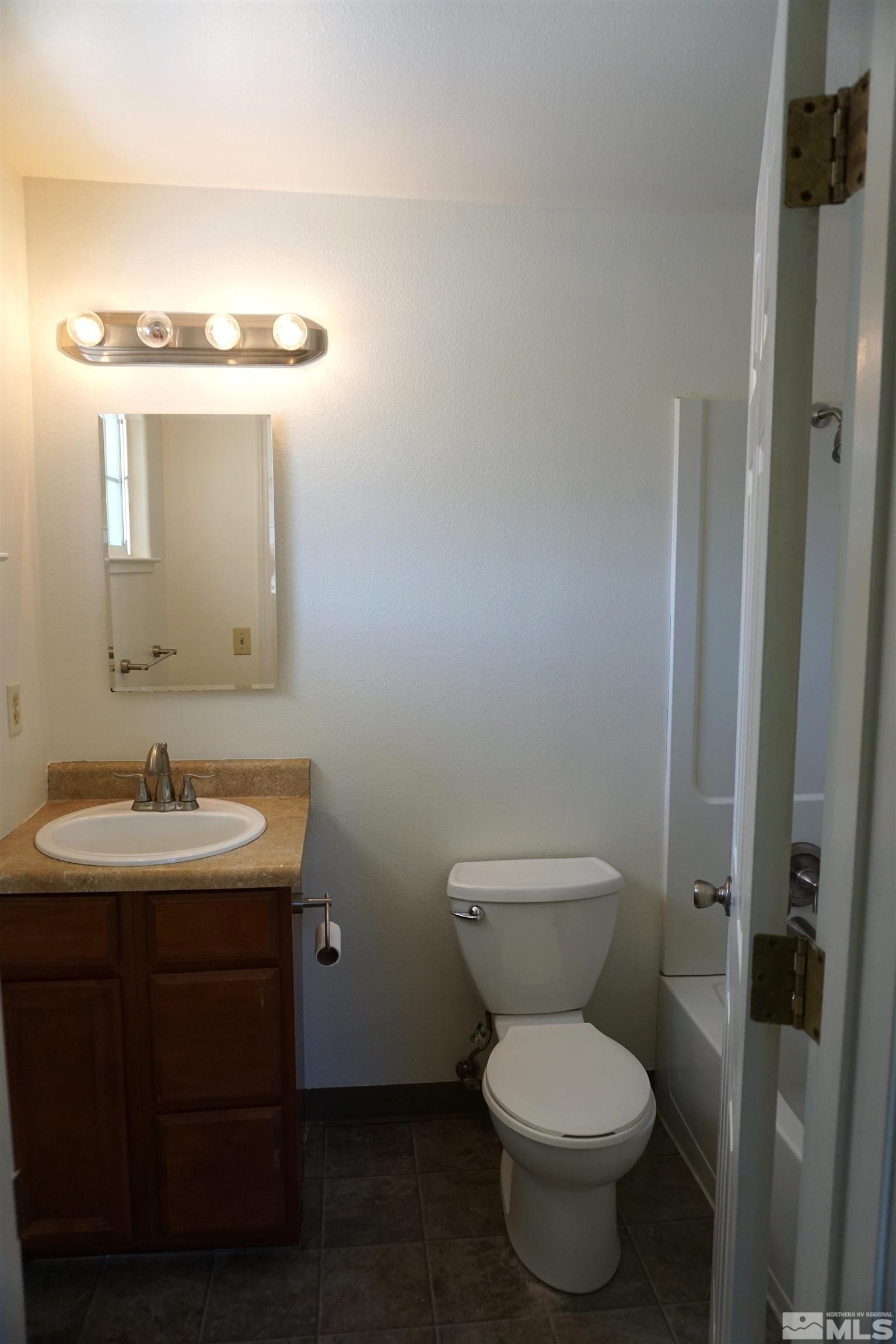 1501 Gault Way Sparks, NV 89431 - Photo 14 of 17 a bathroom with a toilet sink and mirror