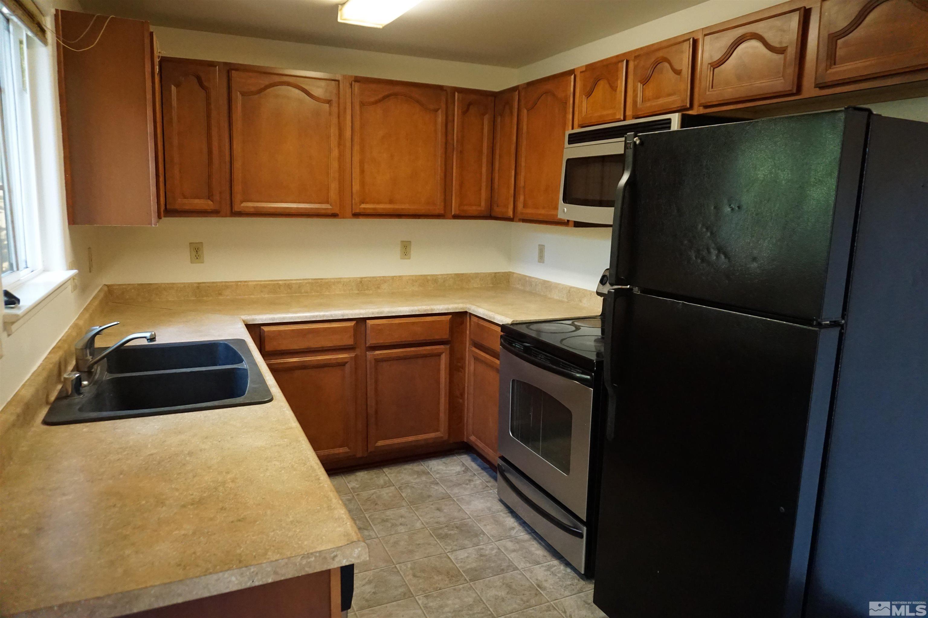 1501 Gault Way Sparks, NV 89431 - Photo 4 of 17 a kitchen with a refrigerator sink and cabinets