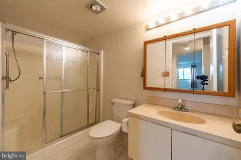 a bathroom with a sink and mirror with toilet