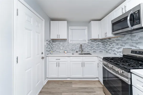 a kitchen with stainless steel appliances granite countertop a stove a sink and a microwave