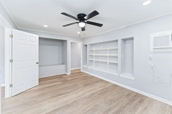 a view of an empty room with a window and wooden floor