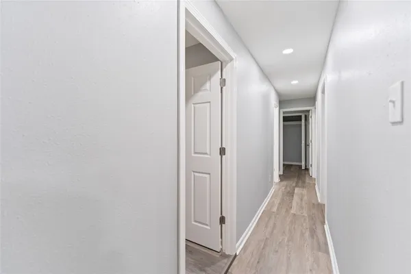 a view of a hallway with wooden floor