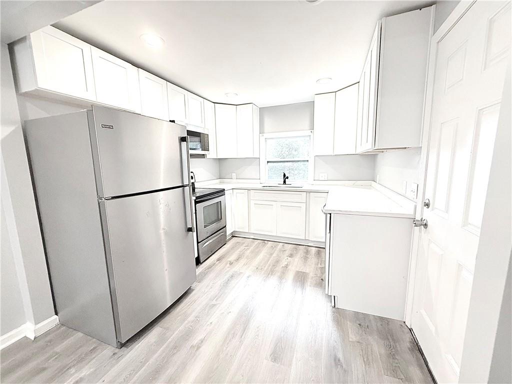 917 Garibaldi Street Southwest Atlanta, GA 30310 - Photo 2 of 9 a kitchen with a refrigerator a sink and cabinets