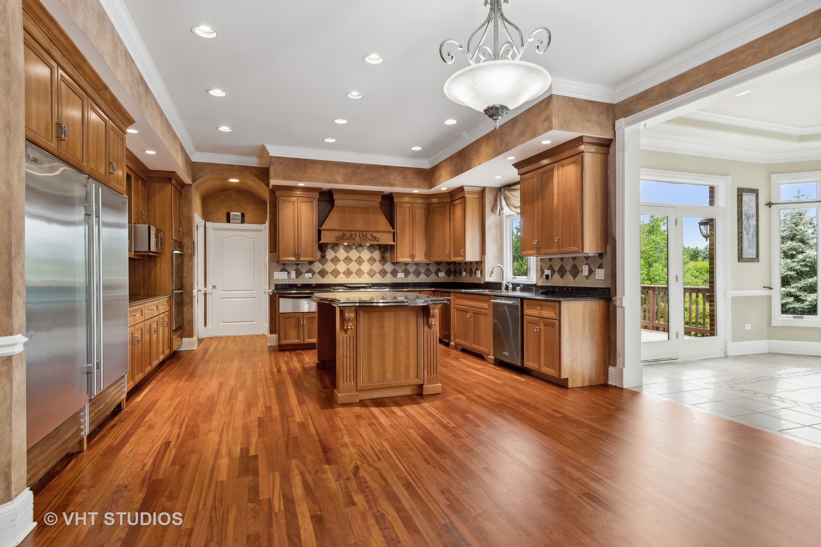 8S287 Hampton Circle Naperville, IL 60540 - Photo 8 of 42 a kitchen with stainless steel appliances kitchen island granite countertop wooden floors and a view of living room