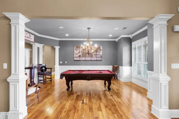 a living room with furniture pool table and flat screen tv