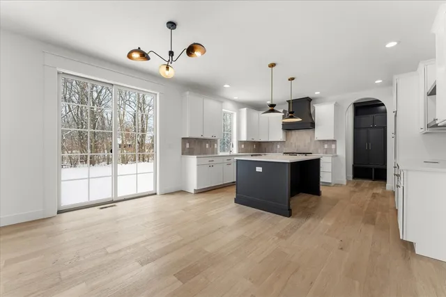 a kitchen with stainless steel appliances granite countertop a sink a stove and a refrigerator