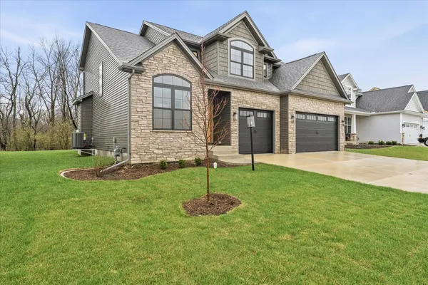 a front view of a house with a yard and green space