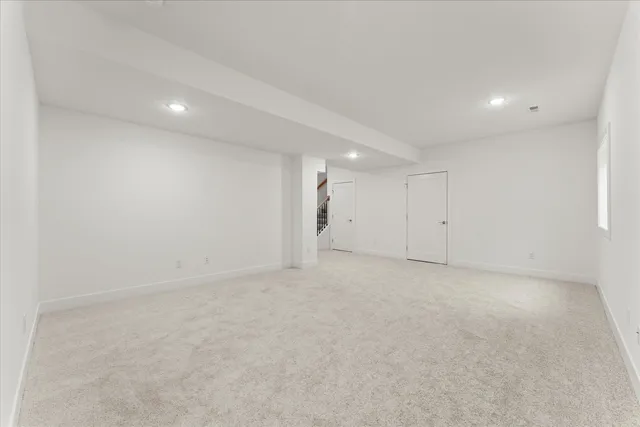 an empty room with a chandelier fan and windows