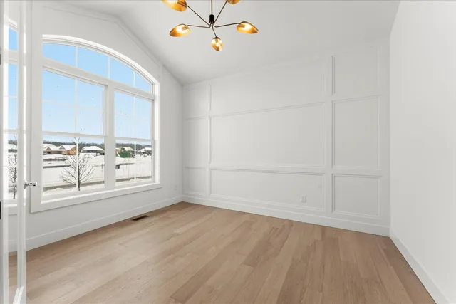 an empty room with cabinet and windows