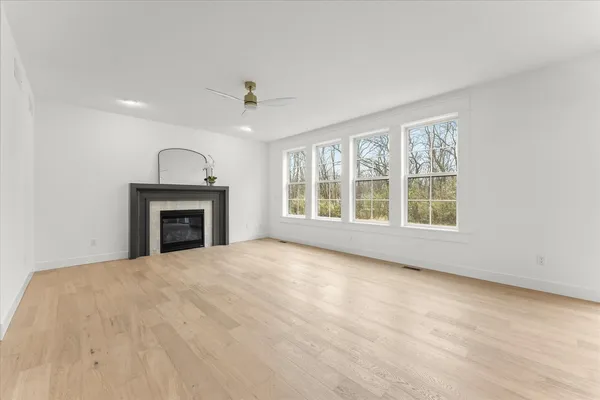 a view of empty room with wooden floor and fireplace