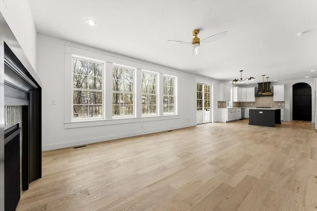 a view of an empty room with window and fire place