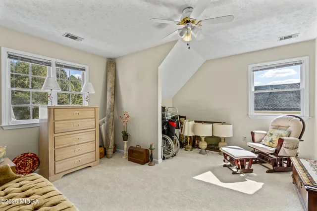 a living room with furniture a couch and a bookshelf