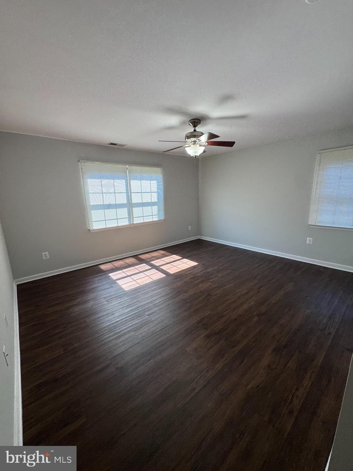 26 Alanbrooke Court, Unit C Towson, MD 21204 - Photo 5 of 9 an empty room with wooden floor and windows