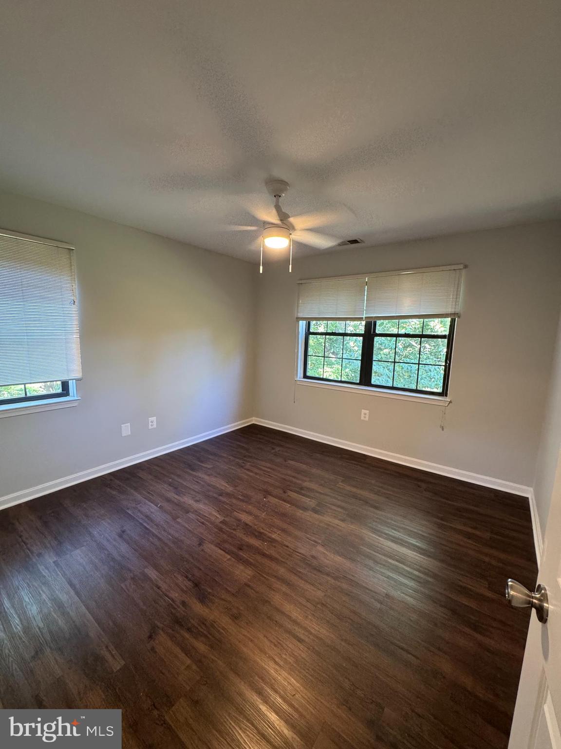 26 Alanbrooke Court, Unit C Towson, MD 21204 - Photo 7 of 9 an empty room with wooden floor and windows