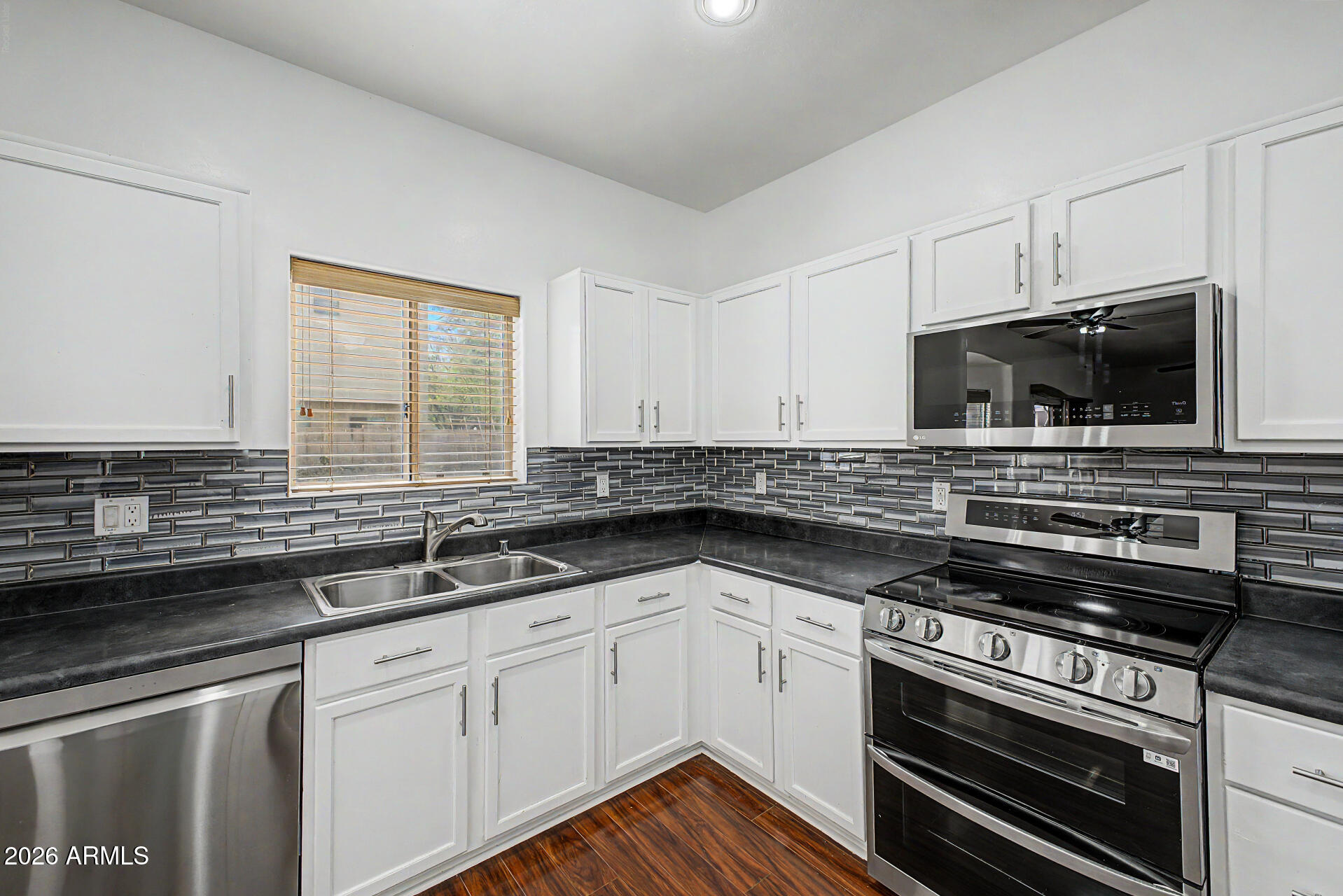 7206 South 12th Way Phoenix, AZ 85042 - Photo 11 of 34 a kitchen with a sink stove and microwave