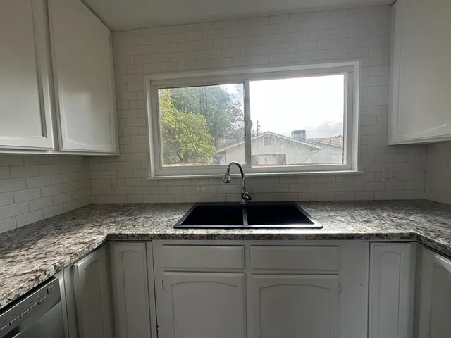 a kitchen with granite countertop a sink and a window
