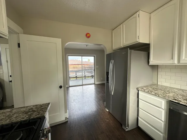 a kitchen with a refrigerator and a stove top oven