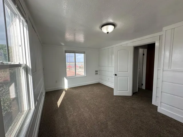 an empty room with windows and closet