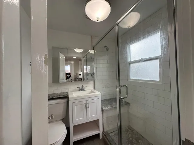 a bathroom with a toilet a sink and mirror