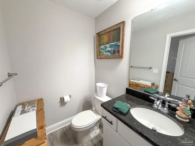a bathroom with a granite countertop toilet sink and mirror