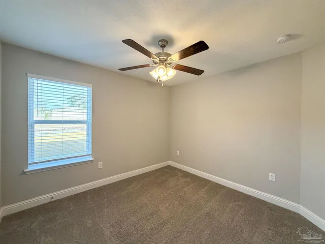 an empty room with closet and a chandelier fan