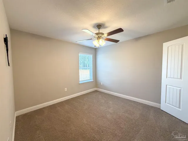 a view of a livingroom with a ceiling fan and window