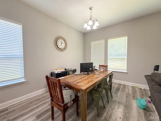 a view of a dining room with furniture a chandelier and wooden floor