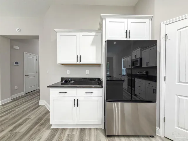 a large kitchen with stainless steel appliances granite countertop a stove and a wooden floors