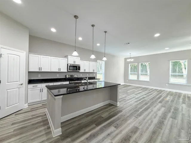 an empty room with wooden floor and mirror