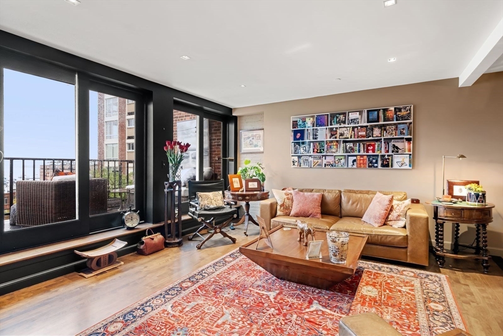 220 Commercial Street, Unit 5A Boston, MA 02109 - Photo 17 of 37 a living room with furniture gym equipment and a floor to ceiling window
