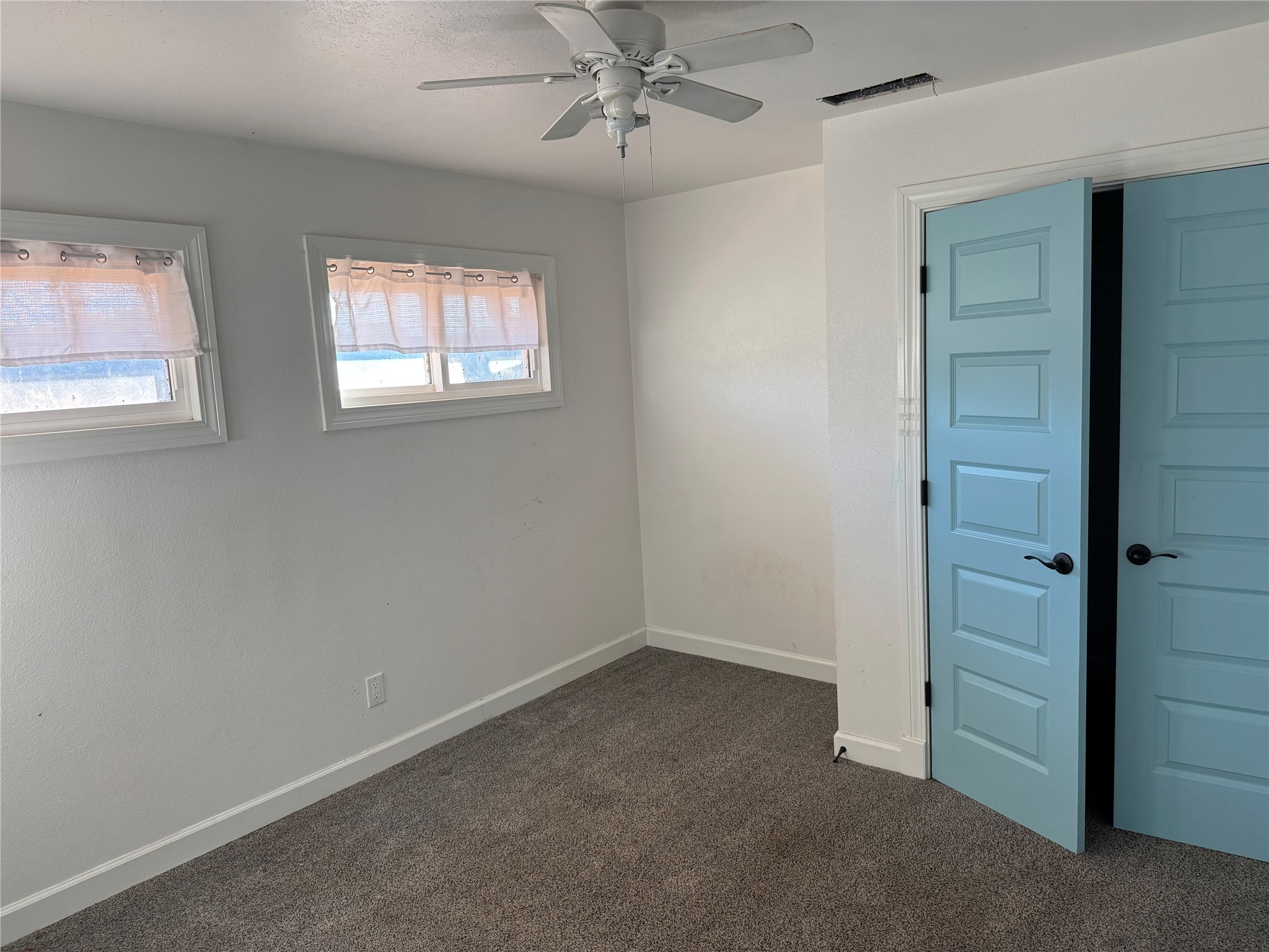 3633 Outback Trail Spicewood, TX 78669 - Photo 23 of 34 Empty room with a ceiling fan and dark carpet