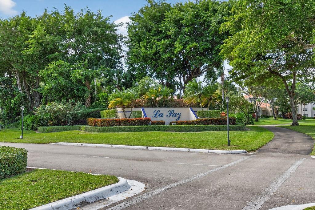 7520 La Paz Court, Unit 209 Boca Raton, FL 33433 - Photo 50 of 55 a front view of a house with a yard and trees