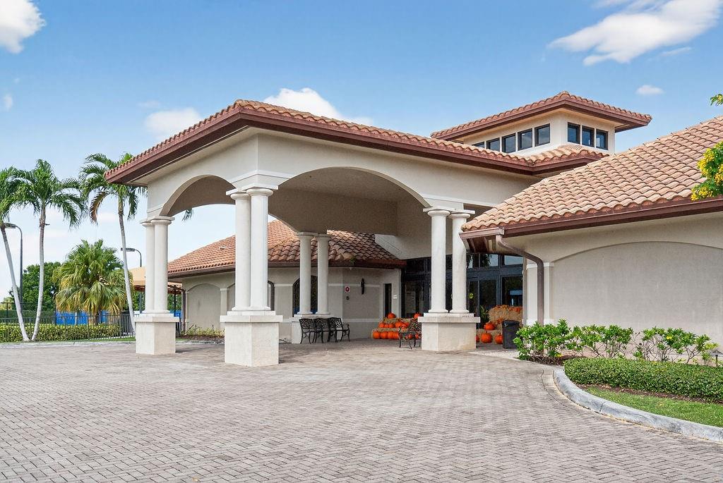 7520 La Paz Court, Unit 209 Boca Raton, FL 33433 - Photo 52 of 55 a front view of a house with a yard