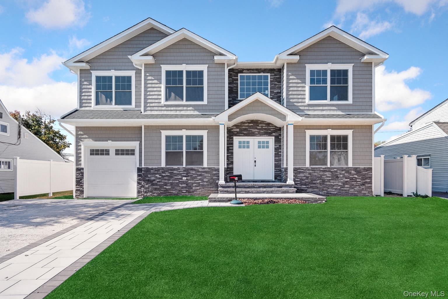 a front view of a house with a yard and trees