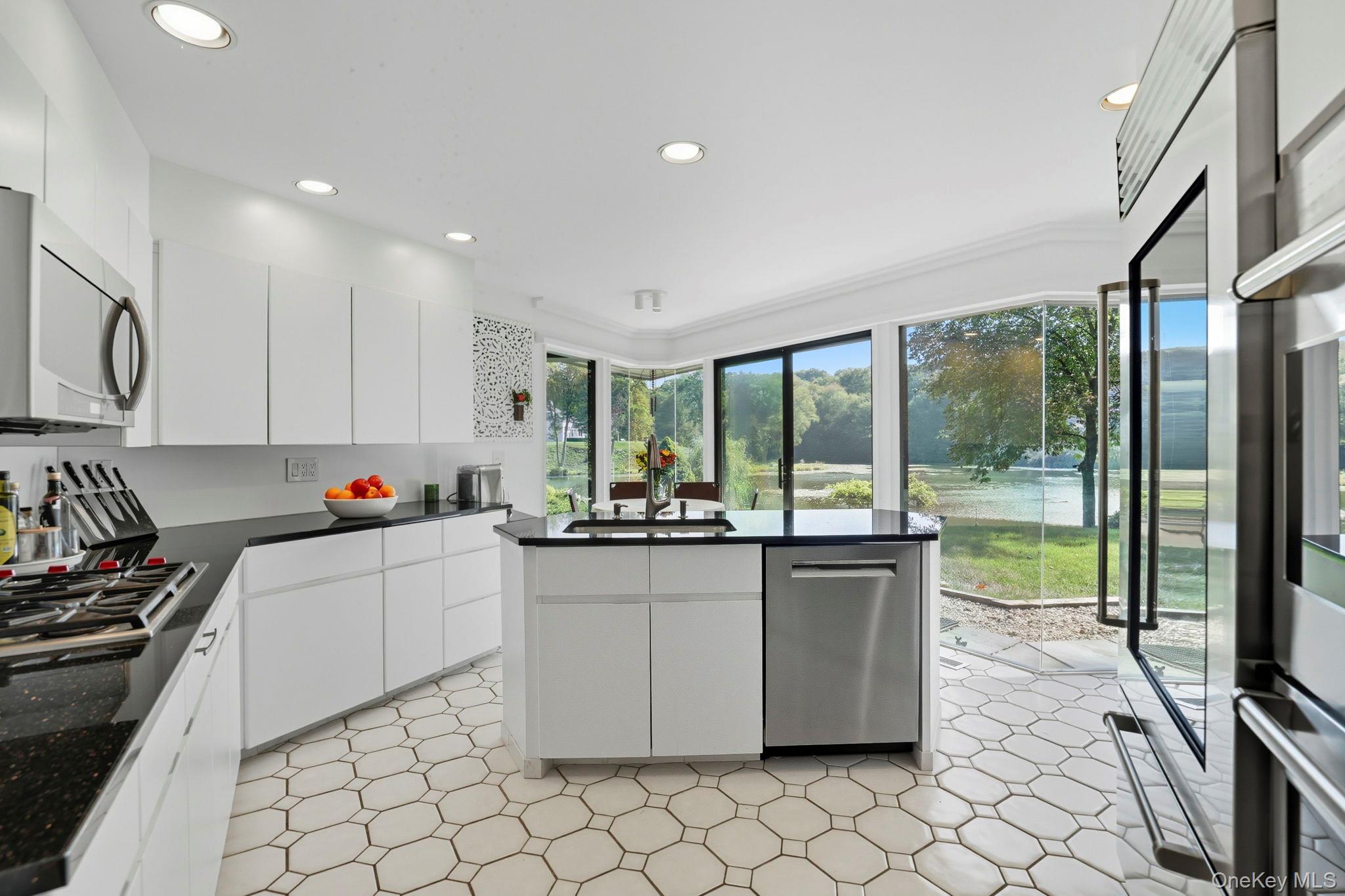 67 Banksville Road Armonk, NY 10504 - Photo 16 of 49 a kitchen with kitchen island granite countertop a sink and white cabinets