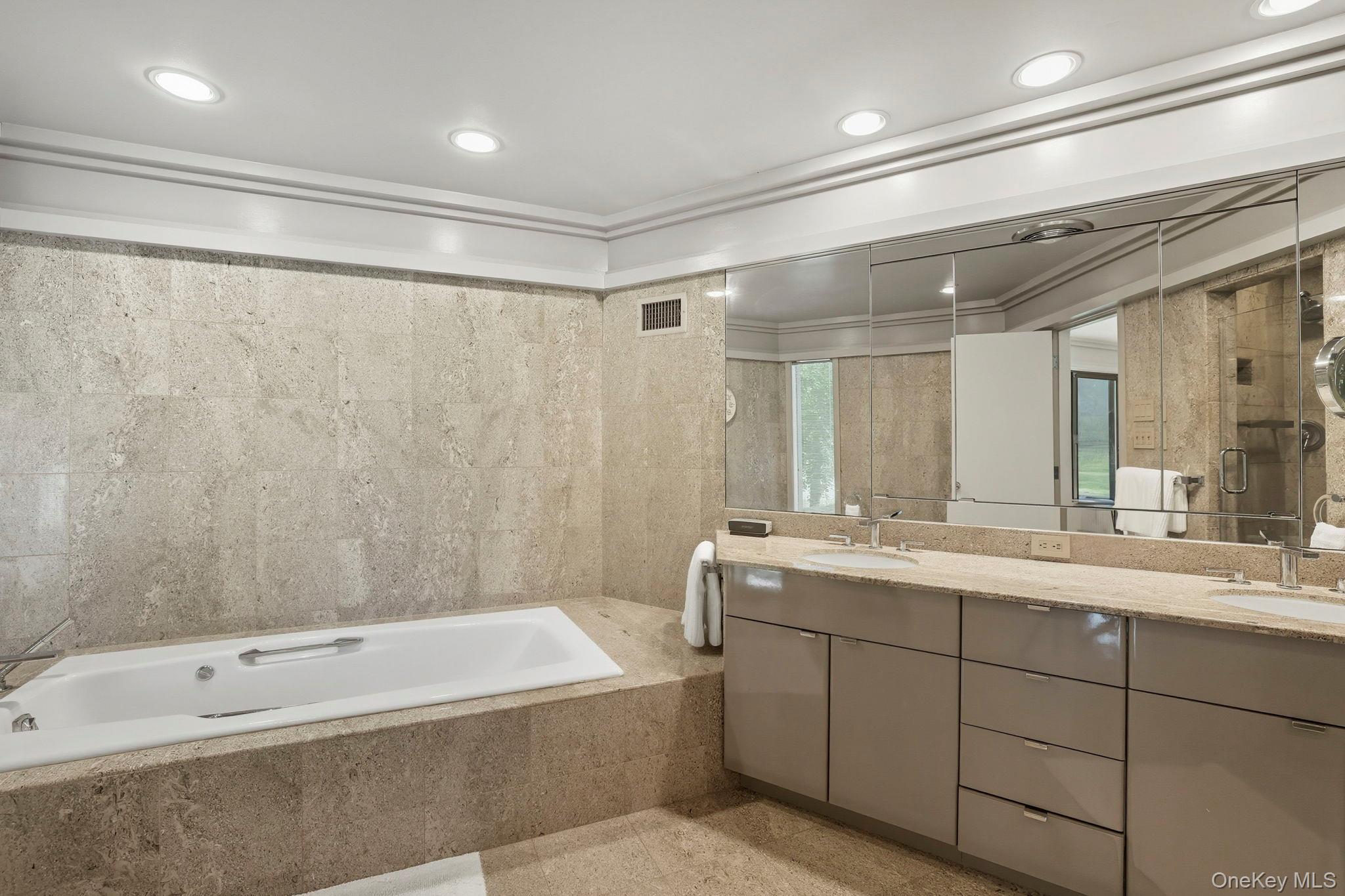 67 Banksville Road Armonk, NY 10504 - Photo 26 of 49 a bathroom with a tub a sink shower and mirror