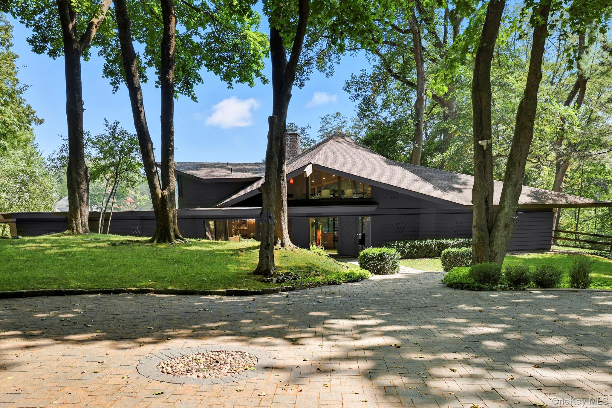 67 Banksville Road Armonk, NY 10504 - Photo 3 of 49 a view of small house in front of a yard with plants and large trees