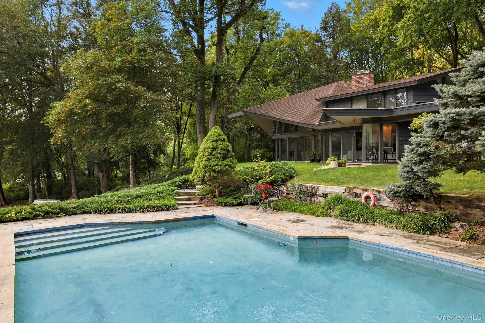 67 Banksville Road Armonk, NY 10504 - Photo 39 of 49 a backyard of a house with a garden and outdoor seating