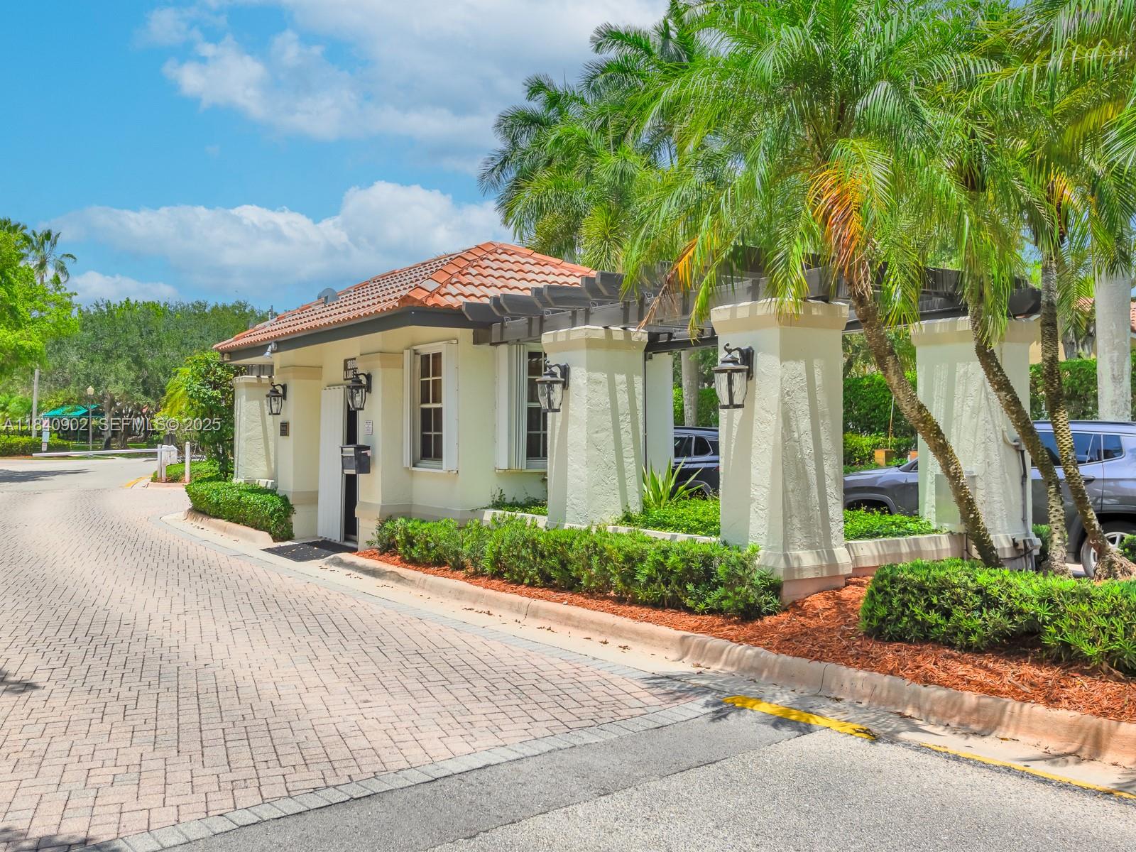933 Falling Water Road Weston, FL 33326 - Photo 2 of 58 a front view of a house with a yard and potted plants