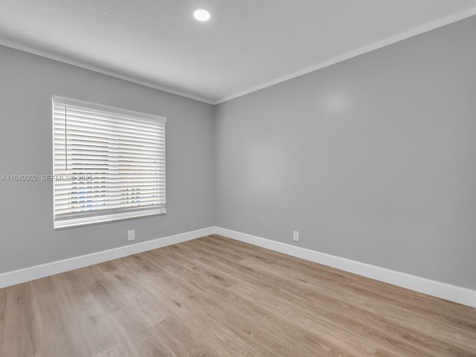 933 Falling Water Road Weston, FL 33326 - Photo 33 of 58 a view of an empty room with wooden floor and a window
