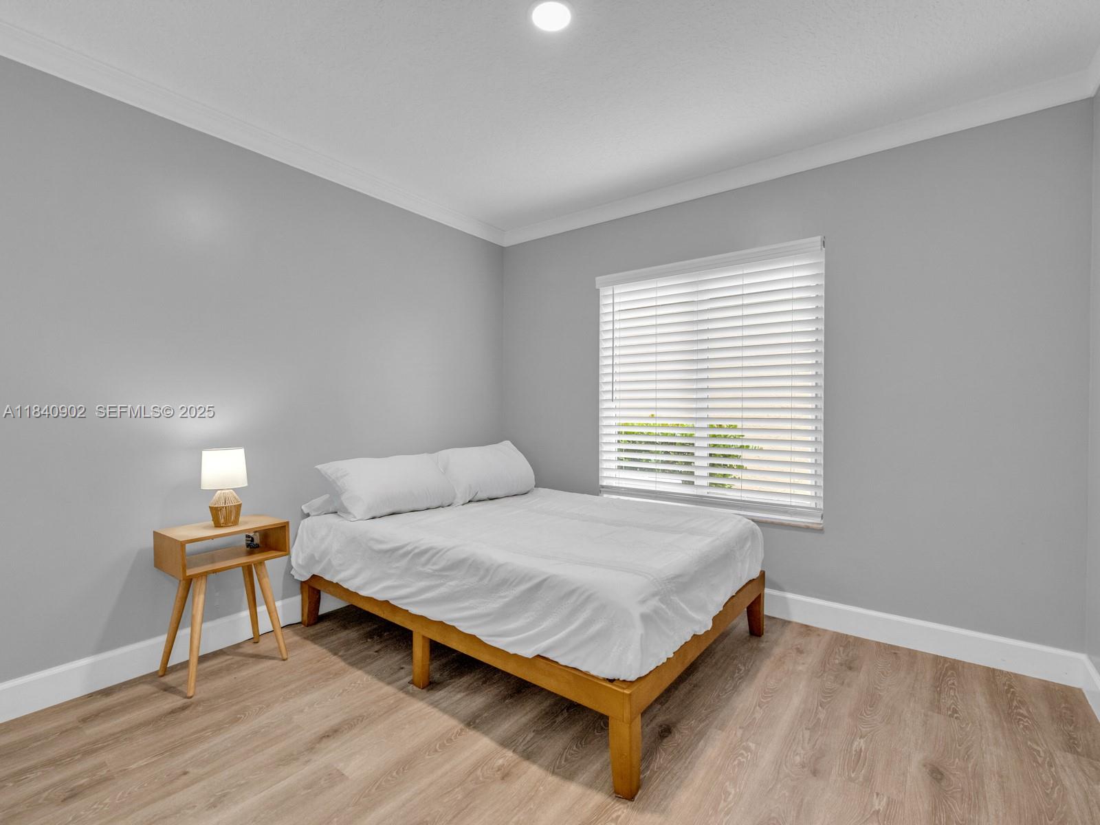 933 Falling Water Road Weston, FL 33326 - Photo 35 of 58 a bedroom with a bed table lamp and a window