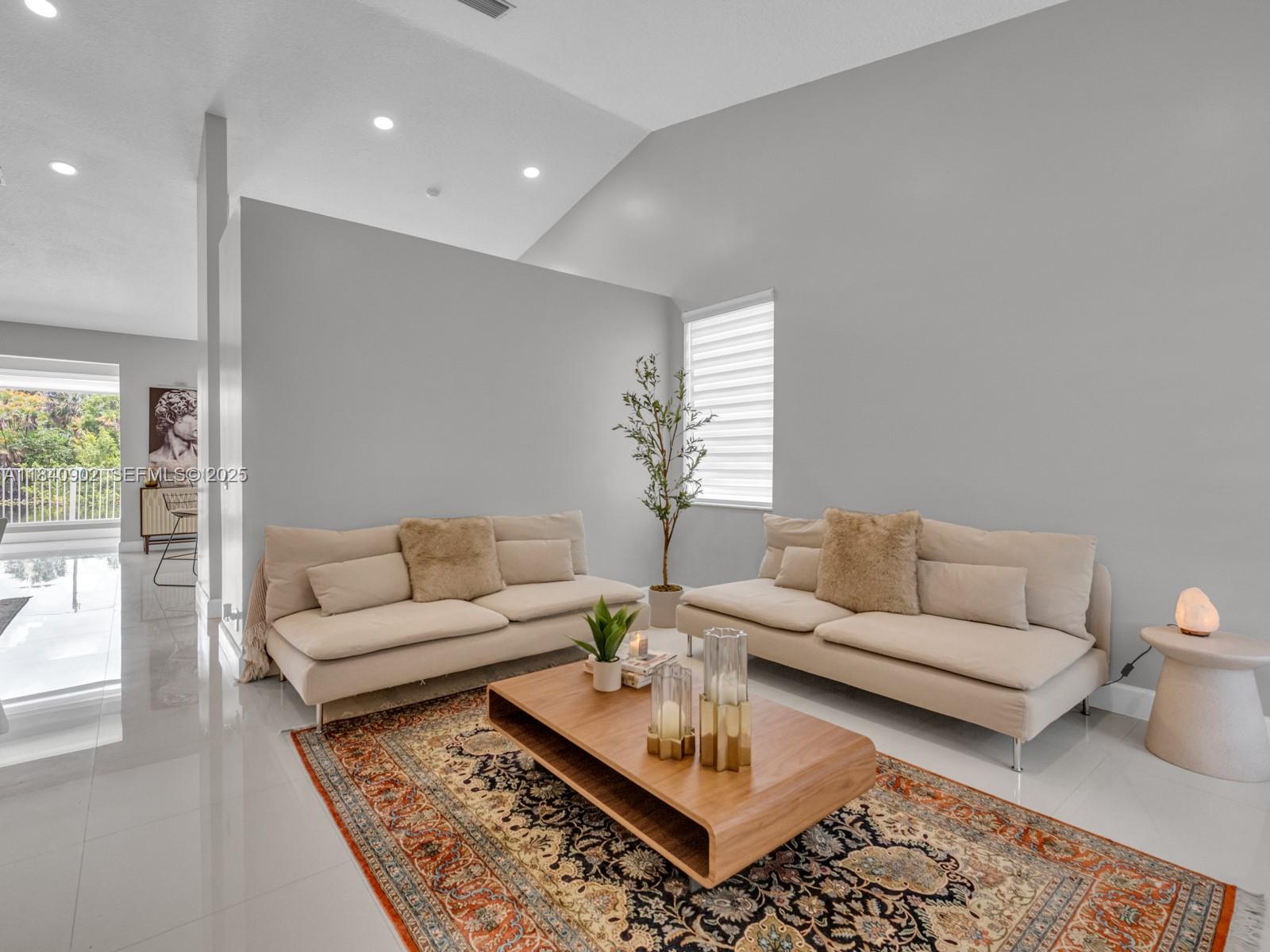 933 Falling Water Road Weston, FL 33326 - Photo 10 of 58 a living room with furniture a rug and a table