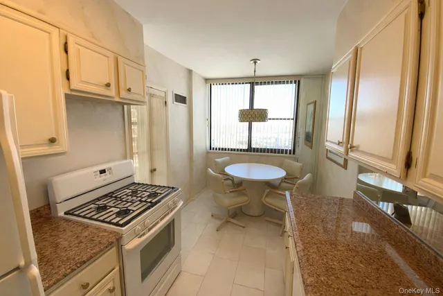 a kitchen with stainless steel appliances granite countertop a stove a refrigerator and a cabinets