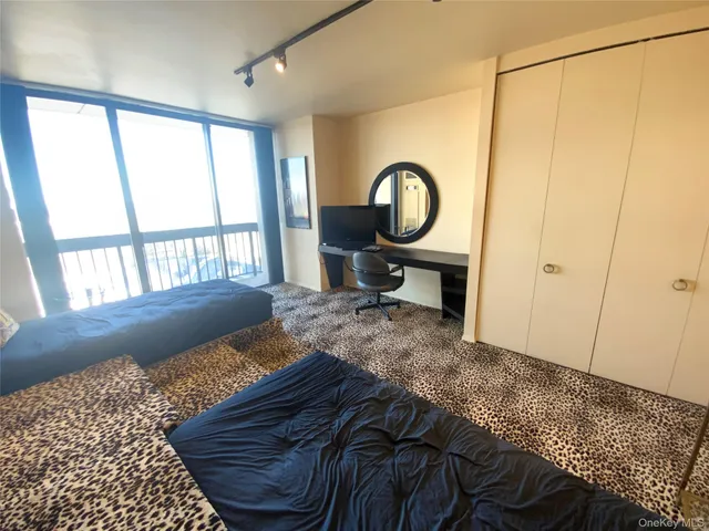 a bedroom with a bed a mirror and a window