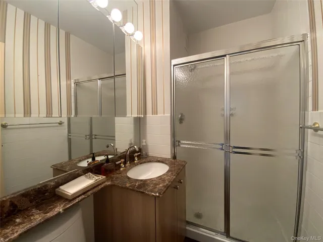 a bathroom with a sink and mirror with toilet
