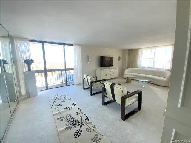 a spacious bedroom with furniture and a flat screen tv