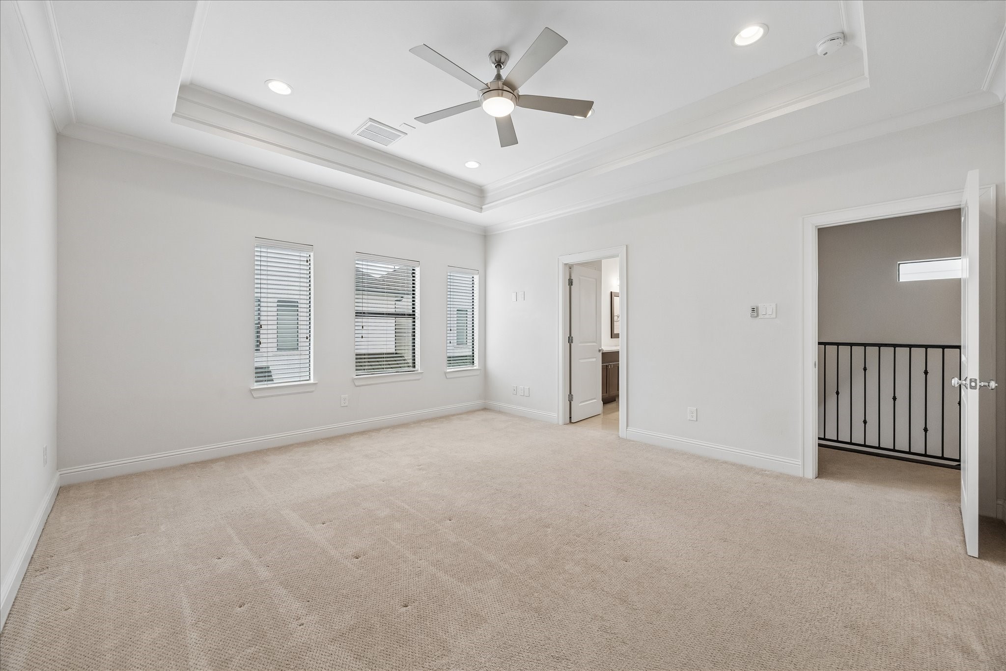 734 West 20th Street, Unit A Houston, TX 77008 - Photo 12 of 23 Spacious third-floor primary suite features tray ceiling w/ crown molding, plush carpeting, abundant natural light & private access to the ensuite bath.