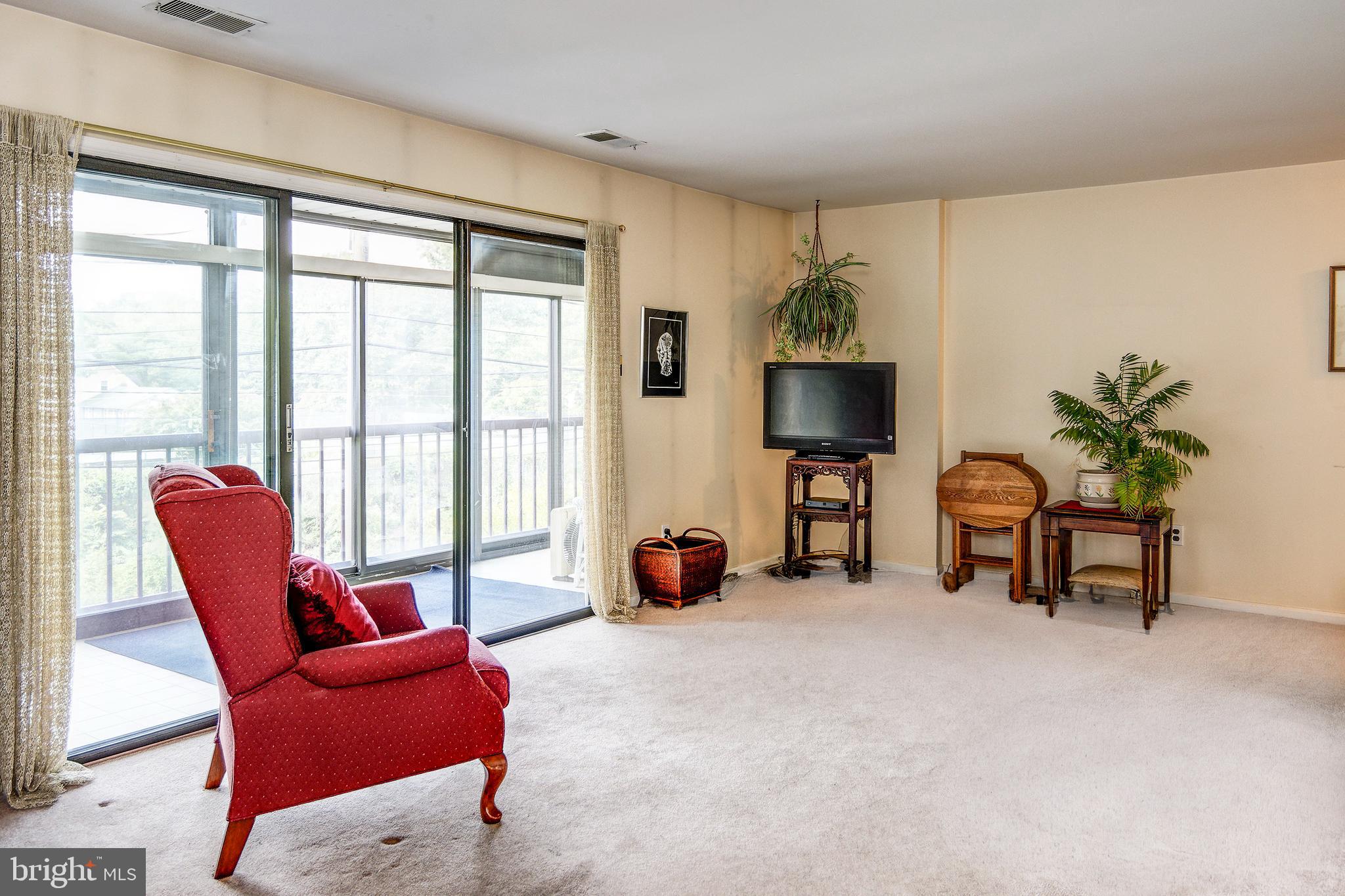 209 Haddonfield Commons, Unit 209 Haddonfield, NJ 08033 - Photo 5 of 21 a living room with furniture and a floor to ceiling window