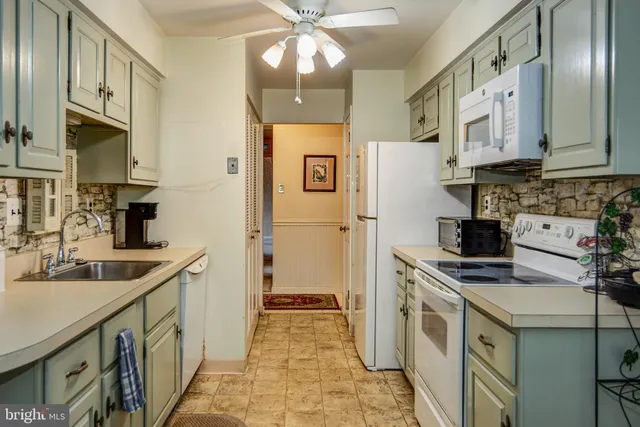 a kitchen with stainless steel appliances a sink stove refrigerator and cabinets